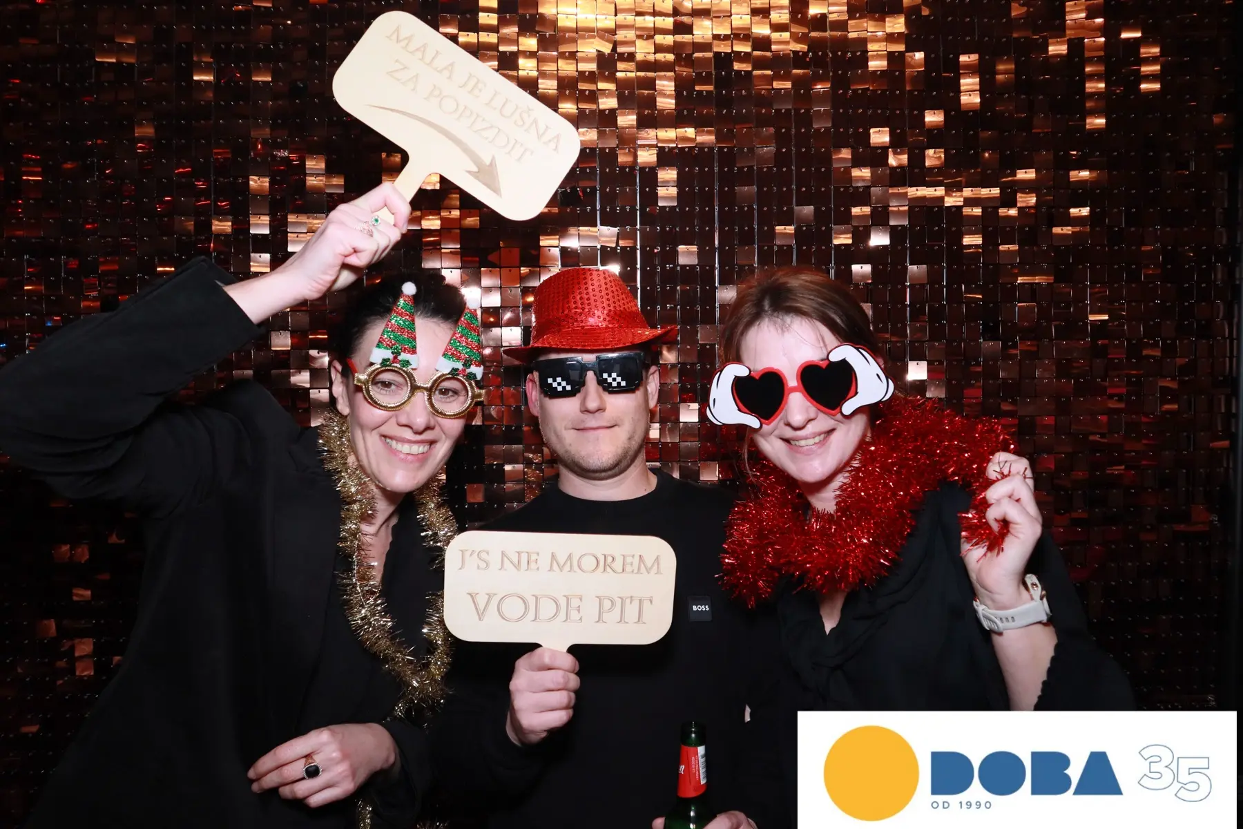 Gostje s Photo Booth rekviziti pred bleščečim ozadjem
